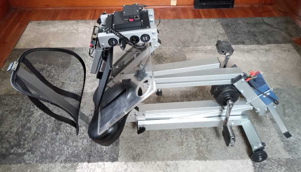 pedal generator stand shown partially folded up and folded on floor